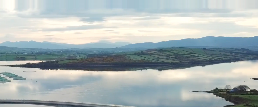 A landscape image of Mulroy Bay in Ireland showing a large body of wter and a sky with clouds.