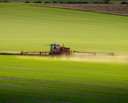 Image of a crop sprayer in a green agricultural field.